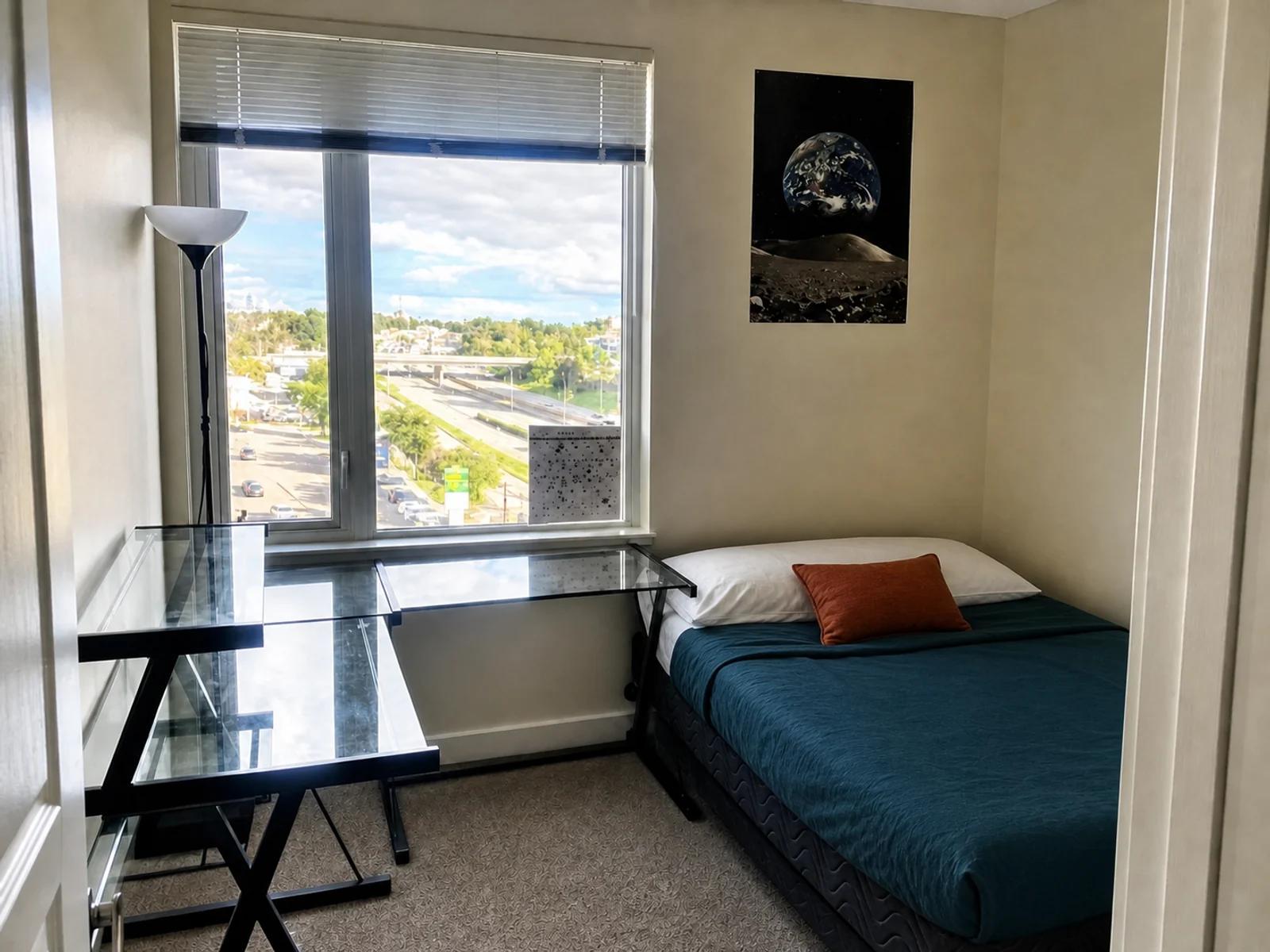 AI-enhanced photo of the compact bedroom and desk in the Brentwood condo